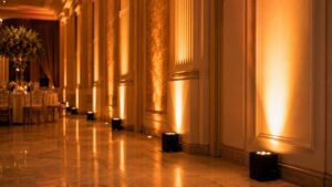 Focos LED uplight inalámbricos iluminando salón de bodas en ámbar