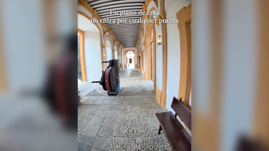 Piano de cola enfundado, camino de un salón del Real Alcázar de Sevilla
