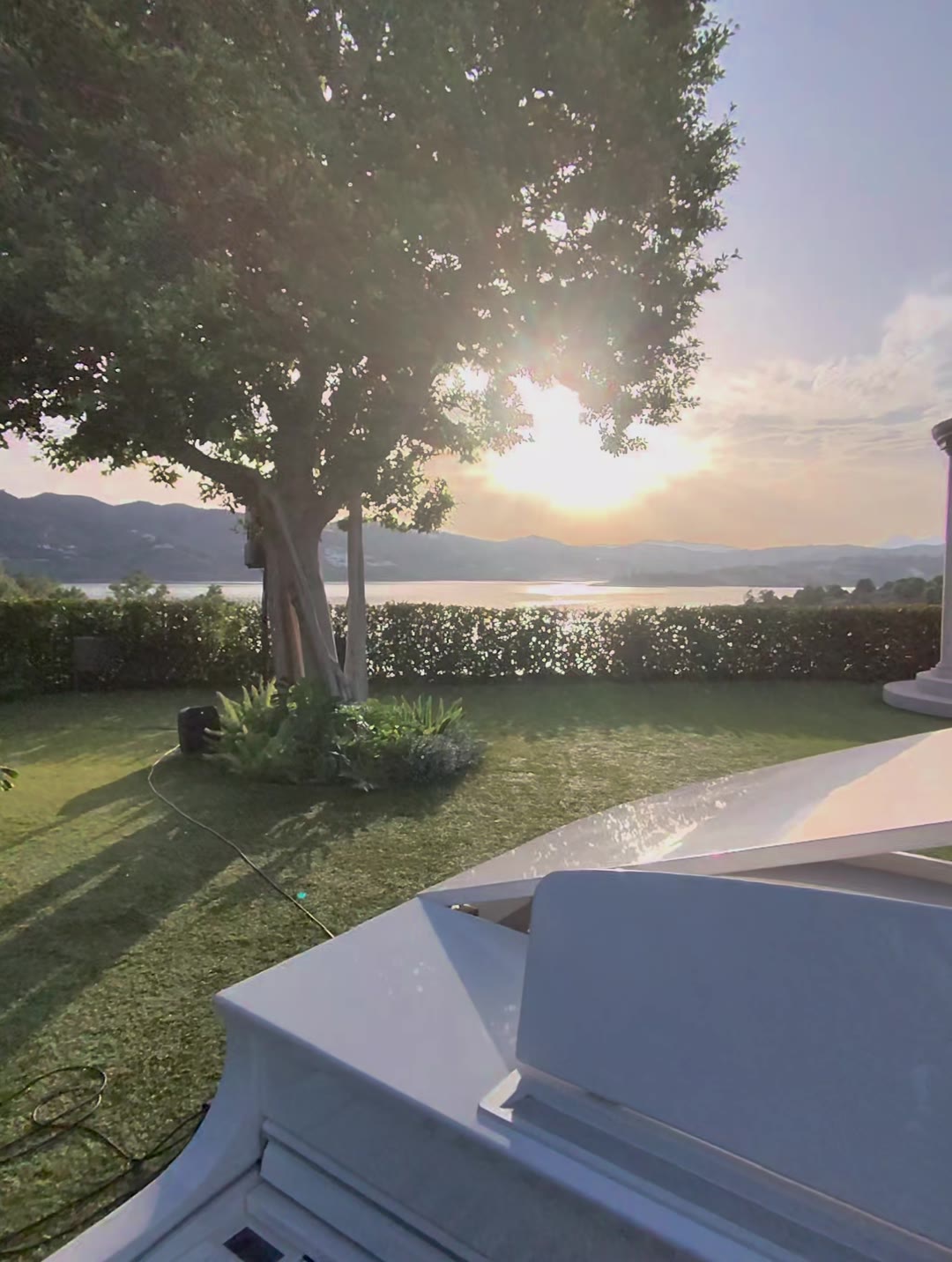 Piano blanco preparado para la ceremonia al atardecer, con el embalse de La Viñuela y las montañas al fondo