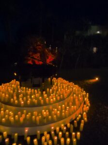 Piano de cola negro en el centro de una espiral de velas LED, de noche, en una boda en BBou La Viñuela (Málaga)